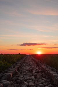 Preview wallpaper road, distance, sunset, stones, grass