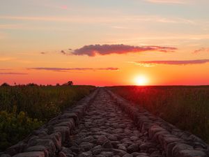 Preview wallpaper road, distance, sunset, stones, grass