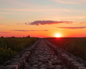 Preview wallpaper road, distance, sunset, stones, grass