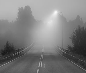 Preview wallpaper road, fog, bridge, streetlights, asphalt, forest, bw