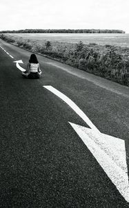 Preview wallpaper road, girl, pose, asphalt, field, bw