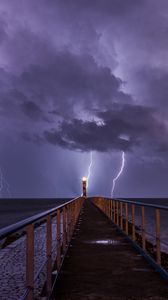 Preview wallpaper road, lighthouse, lightning, sea, dark, clouds