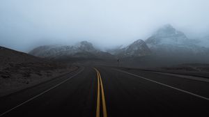 Preview wallpaper road, mountains, fog, turn, rocks