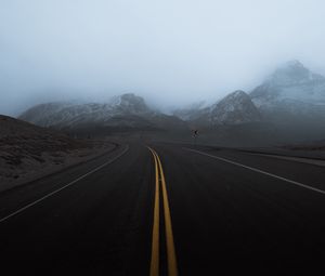 Preview wallpaper road, mountains, fog, turn, rocks