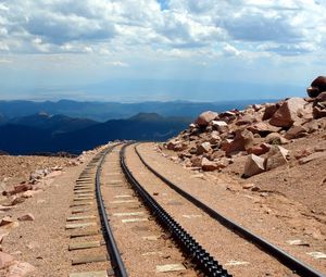 Preview wallpaper road, rails, cross ties, desert, stones, sand, day