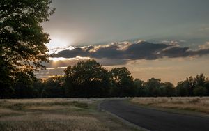Preview wallpaper road, sunset, trees, clouds, sky, sun, rays