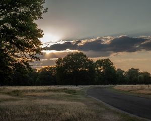 Preview wallpaper road, sunset, trees, clouds, sky, sun, rays