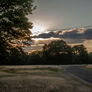 Preview wallpaper road, sunset, trees, clouds, sky, sun, rays