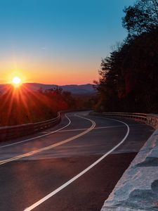 Preview wallpaper road, turn, trees, rays, sunset