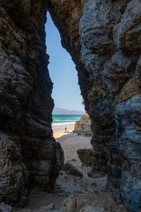 Preview wallpaper rock, arch, beach, man, sea, nature
