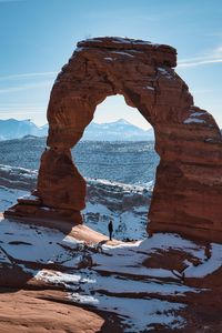 Preview wallpaper rock, arch, man, alone, snow, nature