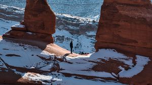 Preview wallpaper rock, arch, man, alone, snow, nature