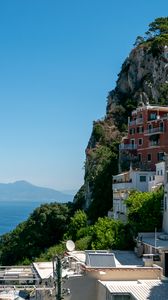 Preview wallpaper rock, buildings, houses, sea, mountain