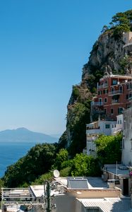 Preview wallpaper rock, buildings, houses, sea, mountain