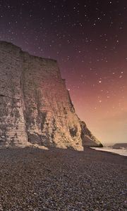 Preview wallpaper rock, cliff, coast, starry sky, pebble