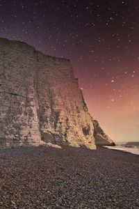 Preview wallpaper rock, cliff, coast, starry sky, pebble