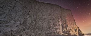 Preview wallpaper rock, cliff, coast, starry sky, pebble