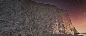 Preview wallpaper rock, cliff, coast, starry sky, pebble