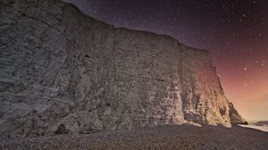 Preview wallpaper rock, cliff, coast, starry sky, pebble