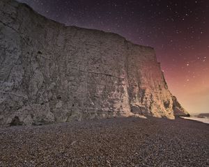 Preview wallpaper rock, cliff, coast, starry sky, pebble