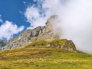 Preview wallpaper rock, cliff, fog, clouds, grass