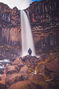 Preview wallpaper rock, mountain, waterfall, man, silhouette, stones