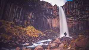 Preview wallpaper rock, mountain, waterfall, man, silhouette, stones