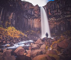 Preview wallpaper rock, mountain, waterfall, man, silhouette, stones