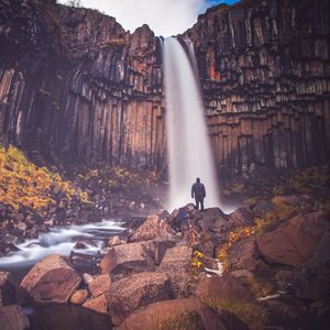 Preview wallpaper rock, mountain, waterfall, man, silhouette, stones