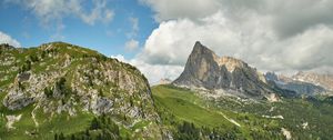 Preview wallpaper rock, peak, slope, grass, clouds