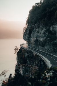 Preview wallpaper rock, road, cliff, sea, sunset