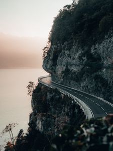 Preview wallpaper rock, road, cliff, sea, sunset