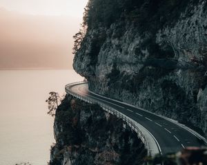 Preview wallpaper rock, road, cliff, sea, sunset