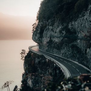 Preview wallpaper rock, road, cliff, sea, sunset