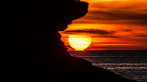Preview wallpaper rock, silhouette, sea, sunset