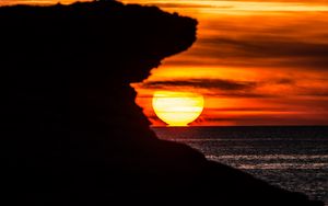 Preview wallpaper rock, silhouette, sea, sunset