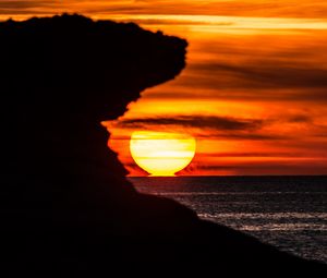 Preview wallpaper rock, silhouette, sea, sunset