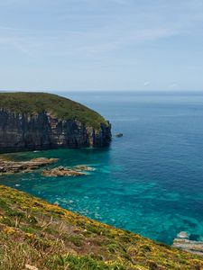 Preview wallpaper rock, slope, sea, grass, sky