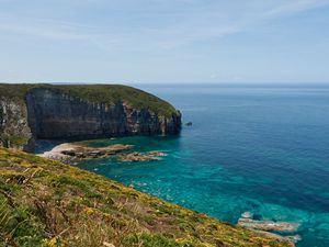 Preview wallpaper rock, slope, sea, grass, sky