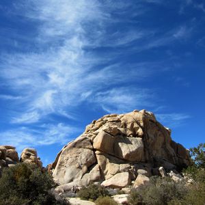 Preview wallpaper rock, stone, stony, bushes, sky