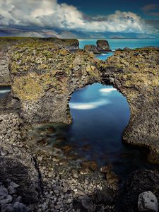 Preview wallpaper rocks, arch, reeves, pebble, stones, sea, coast, clouds, volume, hole