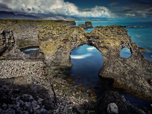 Preview wallpaper rocks, arch, reeves, pebble, stones, sea, coast, clouds, volume, hole