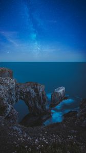 Preview wallpaper rocks, arch, sea, starry sky, horizon, night