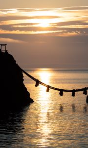 Preview wallpaper rocks, rope, sea, sun, sunset, dark