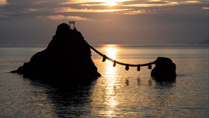 Preview wallpaper rocks, rope, sea, sun, sunset, dark