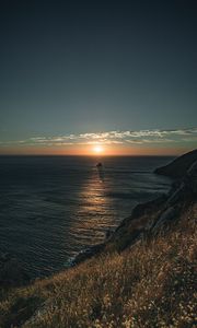 Preview wallpaper rocks, sea, sunset, sun, slope, grass