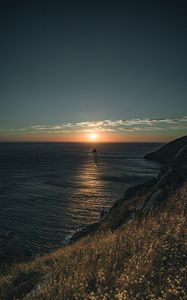 Preview wallpaper rocks, sea, sunset, sun, slope, grass