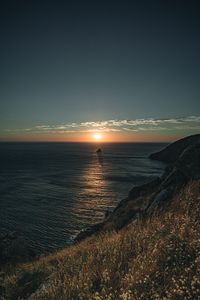 Preview wallpaper rocks, sea, sunset, sun, slope, grass