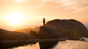 Preview wallpaper rocks, silhouette, sunset, water, south africa