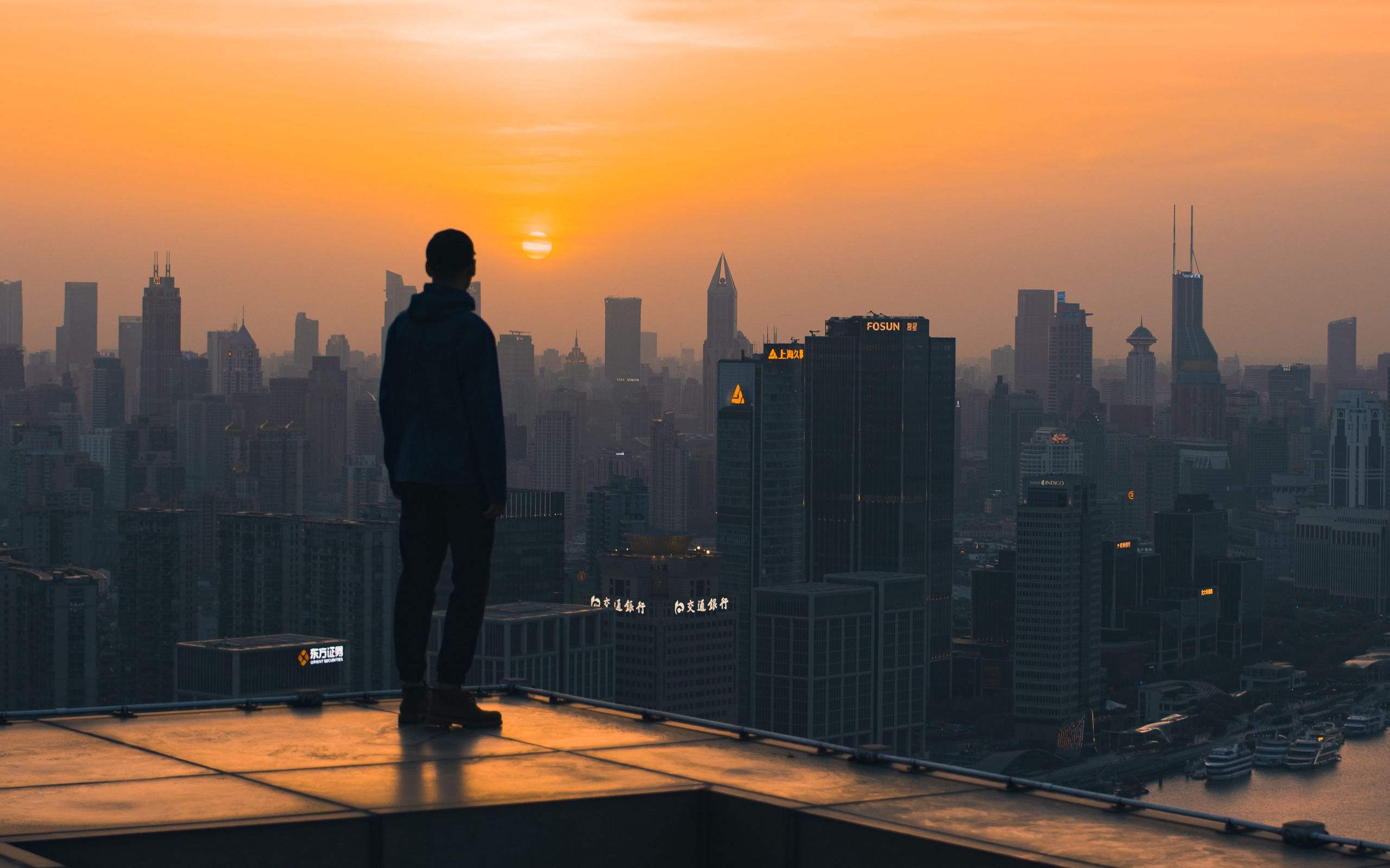 Download wallpaper 2560x1600 roof, man, city, sunset, buildings ...